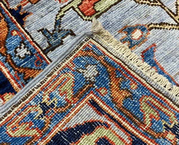 A bold and stunning Aryana 6x9 area rug. This rug features a light blue background with multicolored tribal designs throughout.