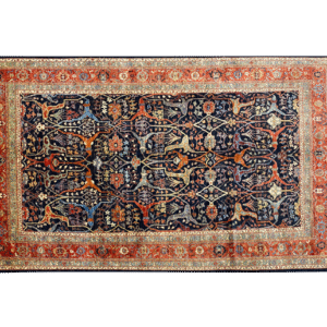 Bold large rug with navy and rust tones and a red and gold border. This area rug is hand-knotted with wool.