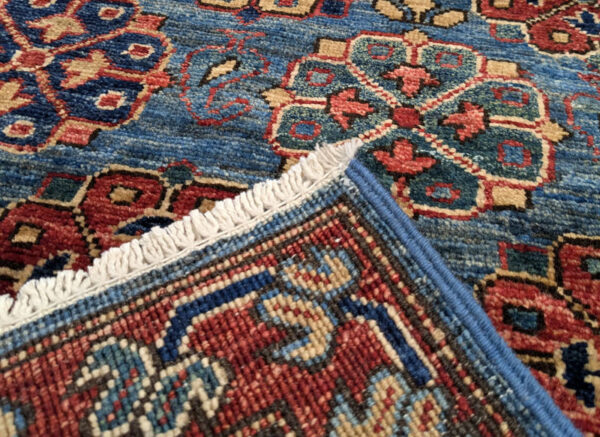Long 3x10 area rug runner with deep blues, orange, and yellows. This rug features a geometric pattern with a border and short fringe.