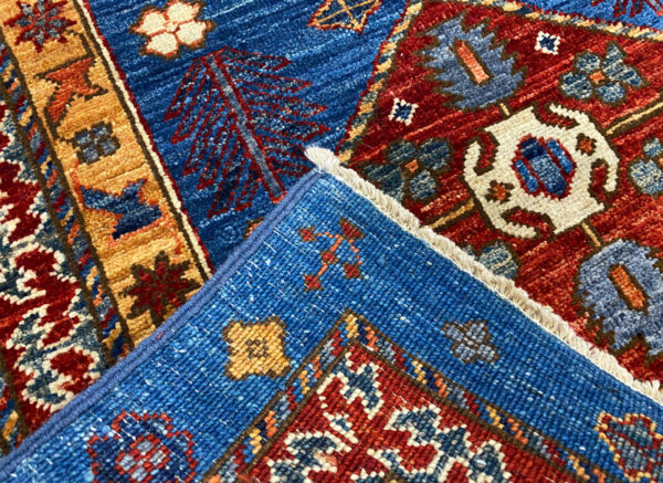 Stunning long 3x10 area rug runner with deep blues, orange, and yellows. This rug features a geometric pattern with a border and short fringe.
