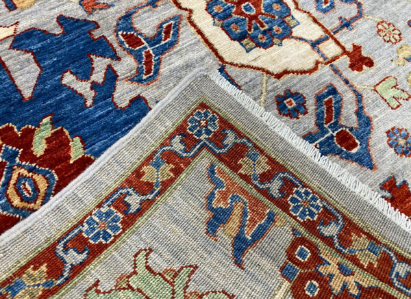 Bright and bold 6x9 area rug with blue and red tones. This area rug is hand-knotted with wool.