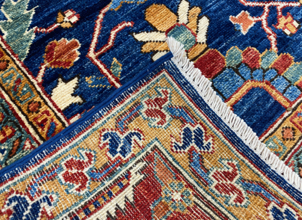Bold large rug with deep blue and red tones. This area rug is hand-knotted with wool.