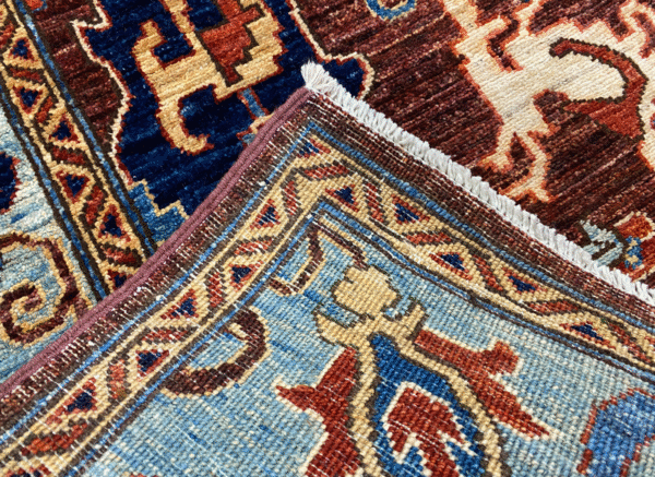 Bold rug with deep blues, reds, and yellow. This rug features a geometric pattern with a border and short fringe.