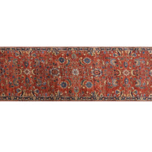 Bold large rug with deep rust tones and a blue border with yellow designs. This area rug is hand-knotted with wool.