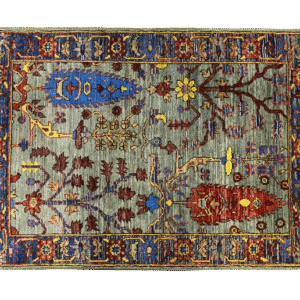 Bold fun large rug with a green background with blue and red trees. This area rug is hand-knotted with wool.