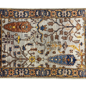 Bold fun large rug with a gray background with blue and red trees. This area rug is hand-knotted with wool.