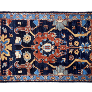 Bold fun small rug with navy, blue and yellow tones and a light blue border. This area rug is hand-knotted with wool.