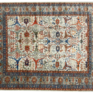 Large 8x10 tribal area rug with a light background and multicolored tribal designs with a large border. This area rug is hand-knotted with wool.