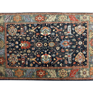 Large 8 x 10 area rug with a navy background and multicolored tribal designs. This rug is hand-knotted with wool.