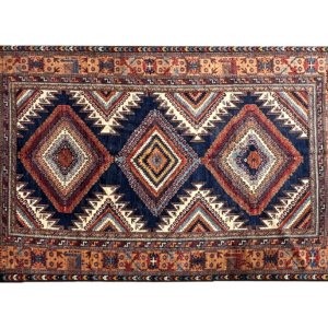 Stunning 7 x 11 area rug with a blue background and multicolored tribal designs. This area rug is hand-knotted with wool.