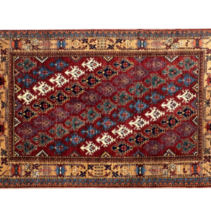 Stunning 5 x 6 area rug with a red background and white and blue designs. This area rug is hand-knotted with wool.