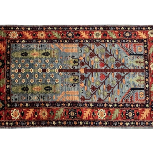 Small 4x7 area rug runner with blue background and a tree design. This rug is hand-knotted with wool.