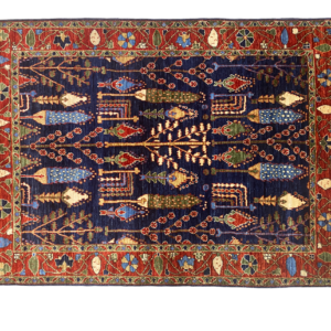 Bright and bold area rug with tribal designs in rich red and blue colors. This rug is hand-knotted with wool.