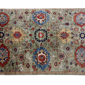 Fun and bright 6x9 area rug with large geometric shapes in blue, red and yellow tones. This rug is hand-knotted with wool.